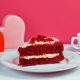 Sweet Carrot Cake with Hearts Decoration against Pink Wall
