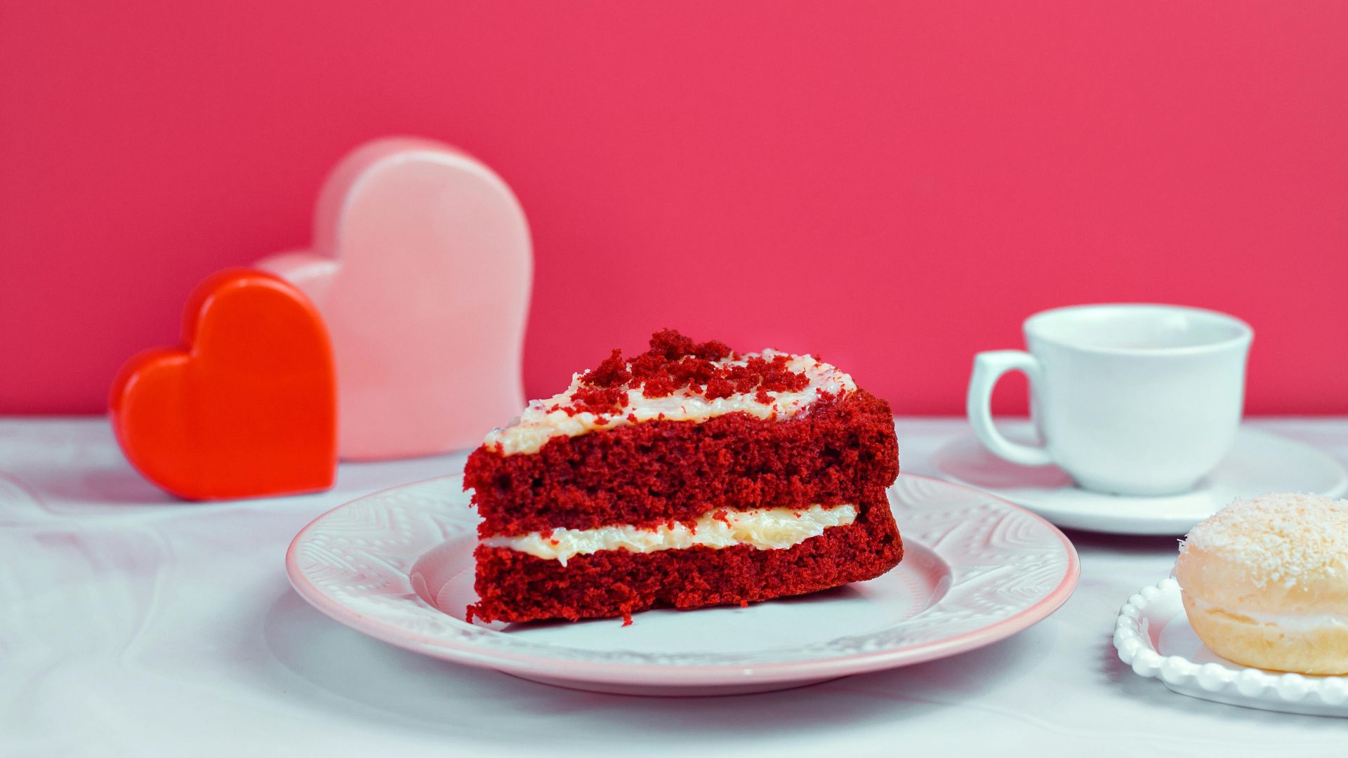 Sweet Carrot Cake with Hearts Decoration against Pink Wall